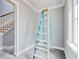 Bright hallway featuring tile floors, staircase, and ladder, freshly painted in a neutral gray tone at 105 Michau Rd., Georgetown, SC 29440