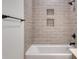 Bathroom featuring a neutral tile shower-tub with shampoo niches and black fixtures, offering a modern style at 1079 Laconic Dr., Myrtle Beach, SC 29588