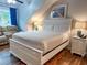 Comfortable bedroom features a bed, side tables, lamps, blue curtains, and luxury vinyl plank flooring at 108 Westhill Circle # 7-E, Myrtle Beach, SC 29572