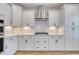 The kitchen features white cabinets, a stylish tile backsplash, stainless steel hood, and wood grain flooring at 1083 Laconic Dr., Myrtle Beach, SC 29588