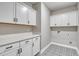 Well-lit laundry room includes patterned flooring, cabinets, and plenty of counter space at 1083 Laconic Dr., Myrtle Beach, SC 29588