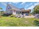 Relaxing backyard with stone patio, a bench, white Adirondack chairs, and well-kept lawn at 1145 Captain Hooks Way, North Myrtle Beach, SC 29582