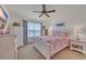 Bright bedroom with a ceiling fan, a window with curtains, and a bed with a colorful comforter at 1145 Captain Hooks Way, North Myrtle Beach, SC 29582