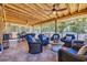 A screened-in outdoor patio with wicker chairs, a table, and a view of the yard at 1145 Captain Hooks Way, North Myrtle Beach, SC 29582