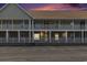The image shows the exterior of the condo building during a colorful sunset at 117 Butkus Dr. # 6, Myrtle Beach, SC 29588
