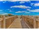 Wooden boardwalk leading to a beautiful beach with the ocean visible in the distance at 1207 Ocean Blvd. S # 20802, Myrtle Beach, SC 29577
