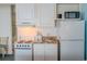 Bright kitchen with oven, sink, microwave, and refrigerator, in a cozy space with a chair at 1207 Ocean Blvd. S # 20802, Myrtle Beach, SC 29577