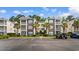 Charming condo complex showcases well-maintained landscaping, palm trees, and convenient parking spaces for residents at 1298 River Oaks Dr. # 5-I, Myrtle Beach, SC 29579