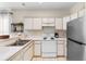 Bright kitchen features white cabinetry, essential appliances, and a dual-basin sink for added convenience at 1298 River Oaks Dr. # 5-I, Myrtle Beach, SC 29579