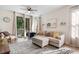 Bright living room featuring a comfortable couch, ottoman, area rug, and access to a balcony at 1298 River Oaks Dr. # 5-I, Myrtle Beach, SC 29579