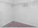 A walk-in closet offers ample storage space with wire shelving, carpeting, and wooden hangers at 136 Dagger Ct., Myrtle Beach, SC 29588