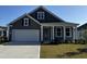 Charming single-Gathering home featuring a gray exterior, manicured lawn, and a two-car garage at 149 Stride Ct., Myrtle Beach, SC 29588