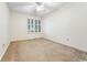 A bright bedroom featuring neutral carpet, a ceiling fan, and a window with shutters at 159-1 Weehawka Way # 159-1, Pawleys Island, SC 29585