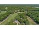Aerial view of a golf course with lush green fairways, a pond, and surrounding trees and luxury home at 159-1 Weehawka Way # 159-1, Pawleys Island, SC 29585