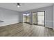 Open living area with sliding glass doors to balcony; hardwood floors and neutral paint at 1600 Deer Creek Rd. # F, Myrtle Beach, SC 29575