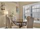 Charming dining area with a round table, cushioned chairs, and a window with shutter blinds at 1631 Hepburn Dr., Little River, SC 29566