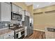 Close-up of kitchen with stainless steel appliances, granite countertops, tile backsplash, and wooden floors at 1631 Hepburn Dr., Little River, SC 29566