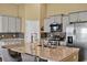 Bright kitchen features stainless steel appliances, granite counters, and gray cabinetry at 1631 Hepburn Dr., Little River, SC 29566