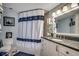 Cozy bathroom featuring blue-and-white themed shower curtain and a granite countertop sink at 1990 N Waccamaw Dr. # 1008, Murrells Inlet, SC 29576