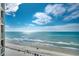 Elevated beach view showcasing a wide sandy beach, clear blue ocean, and vibrant blue sky with puffy clouds at 1990 N Waccamaw Dr. # 1008, Murrells Inlet, SC 29576