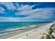 Panoramic beach view showcasing a wide sandy beach, clear blue ocean, and vibrant blue sky with puffy clouds at 1990 N Waccamaw Dr. # 1008, Murrells Inlet, SC 29576