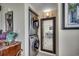 A laundry area featuring stackable washer and dryer, complemented by neutral-toned walls and a decorative mirror at 1990 N Waccamaw Dr. # 1008, Murrells Inlet, SC 29576