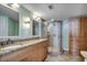 Well-lit bathroom featuring a double sink vanity, glass-enclosed shower, and neutral tiling at 1990 N Waccamaw Dr. # 807, Murrells Inlet, SC 29576