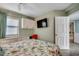 Bedroom featuring a TV, built in desk, neutral tones, and a bed with floral bedding at 1990 N Waccamaw Dr. # 807, Murrells Inlet, SC 29576