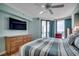 Comfortable main bedroom with balcony access, featuring a TV and striped bedding at 1990 N Waccamaw Dr. # 807, Murrells Inlet, SC 29576
