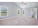 Light filled bedroom featuring carpet, two windows, ceiling fan, and a glass panel door leading to the backyard at 2004 Potomac Ct., Myrtle Beach, SC 29579