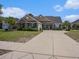 Charming brick home with a well-manicured lawn, palm trees, and a long driveway leading to the garage at 2004 Potomac Ct., Myrtle Beach, SC 29579