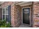 Close-up of the home's front door, showing brickwork, window and door details, and black shutters at 2004 Potomac Ct., Myrtle Beach, SC 29579