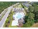 Aerial view showcases the community's pool, lounge chairs, lush greenery, and neighborhood at 2020 Willow Run Dr. # D, Little River, SC 29566