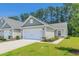 Inviting single-story home with a two-car garage, complimented by lush green grass and a clear blue sky at 2020 Willow Run Dr. # D, Little River, SC 29566