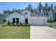 Inviting single-story home with white siding, black roof, and well-kept front yard landscaping at 212 Carolina Lakes Blvd., Myrtle Beach, SC 29588