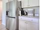 Modern kitchen with stainless steel refrigerator, white cabinets, and granite countertops at 212 Carolina Lakes Blvd., Myrtle Beach, SC 29588