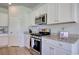 Well-lit kitchen features stainless steel appliances, granite countertops, and white cabinetry at 212 Carolina Lakes Blvd., Myrtle Beach, SC 29588