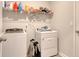 A practical laundry room with modern washer and dryer units and organized shelving above at 212 Carolina Lakes Blvd., Myrtle Beach, SC 29588