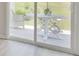 View of the outdoors from behind a sliding glass door with a patio table and chairs at 212 Carolina Lakes Blvd., Myrtle Beach, SC 29588