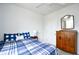 Bright bedroom featuring a comfortable bed with blue plaid bedding and a vintage wooden dresser at 2315 Blackthorn Dr., Conway, SC 29526
