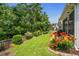 Picturesque backyard with vibrant flower beds, manicured lawn, and mature trees bordering the property line at 2318 Via Palma Dr., North Myrtle Beach, SC 29582