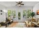 Bright sunroom features a ceiling fan, ample natural light, and views of the beautifully landscaped backyard at 2318 Via Palma Dr., North Myrtle Beach, SC 29582