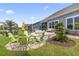 The backyard has a stone patio with colorful chairs, lush landscaping, and serene waterfront views at 2572 Brescia St., Myrtle Beach, SC 29579