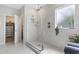 Bright bathroom featuring a glass shower with marble-style tiling, a window, and neutral decor at 2572 Brescia St., Myrtle Beach, SC 29579