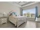 Bedroom with a tray ceiling, floral bedding, side tables, and large bright window at 2572 Brescia St., Myrtle Beach, SC 29579