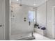 Bright bathroom featuring a glass shower with marble-style tiling, a window, and neutral decor at 2572 Brescia St., Myrtle Beach, SC 29579
