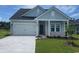 Charming one-story home with light blue siding, a front-facing garage, and a well-manicured lawn at 2606 Tranquility Loop, Longs, SC 29568