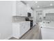 Bright kitchen features stainless appliances, gray backsplash, and white cabinetry with modern hardware at 2610 Tranquility Loop, Longs, SC 29568