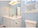 Bathroom featuring double sinks, a large mirror, a toilet, and a window with blinds for natural light at 264 La Patos Dr., Myrtle Beach, SC 29588