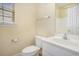 Bathroom showing a toilet and sink with vanity next to a window with blinds for natural lighting at 264 La Patos Dr., Myrtle Beach, SC 29588